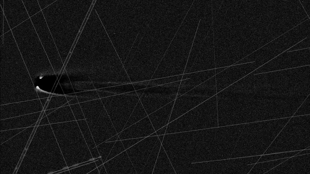 تصویری سیاهسفید از یک ستاره دنبالهدار با خطوط عبوری در سراسر تصویر.